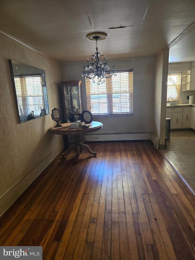 dining room with a baseboard radiator, plenty of natural light, hardwood / wood-style floors, and a notable chandelier