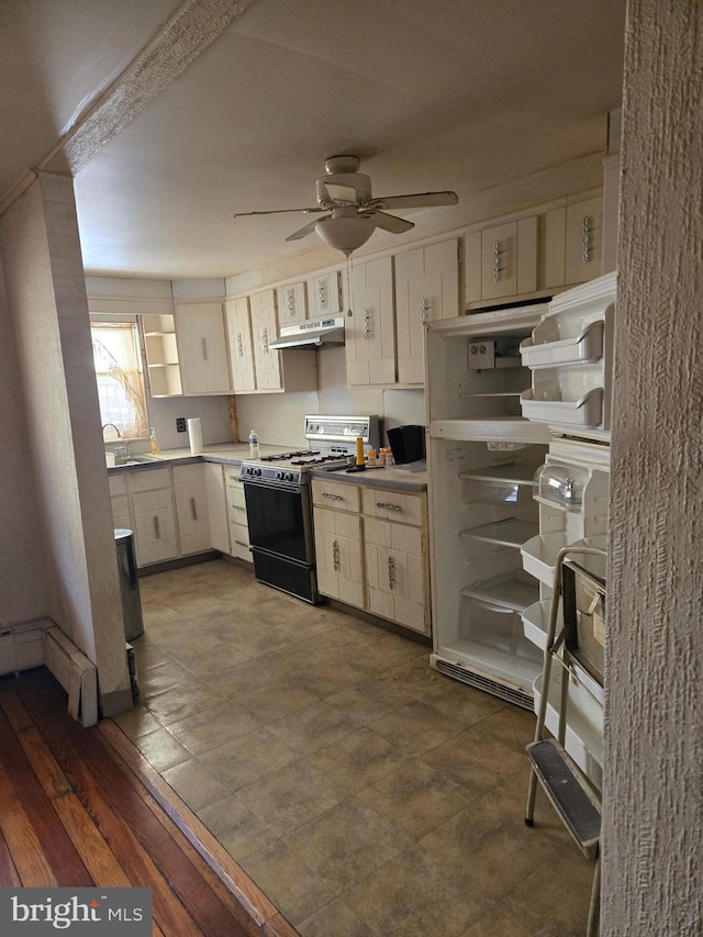 kitchen featuring a baseboard radiator, open shelves, under cabinet range hood, gas stove, and a ceiling fan