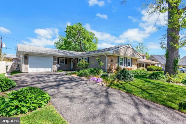 single story home featuring fence, driveway, stone siding, and a garage