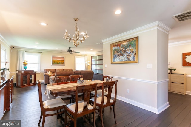 dining space with crown molding, dark wood finished floors, a wealth of natural light, and visible vents