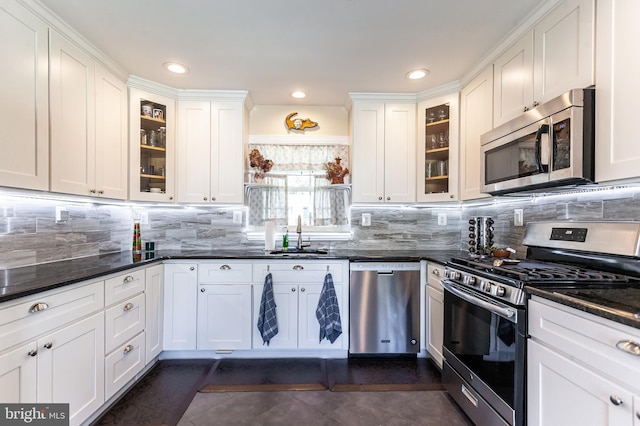 kitchen with stainless steel appliances, white cabinetry, a sink, and tasteful backsplash