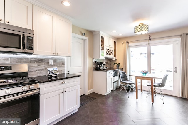 kitchen with glass insert cabinets, recessed lighting, white cabinets, tasteful backsplash, and stainless steel appliances