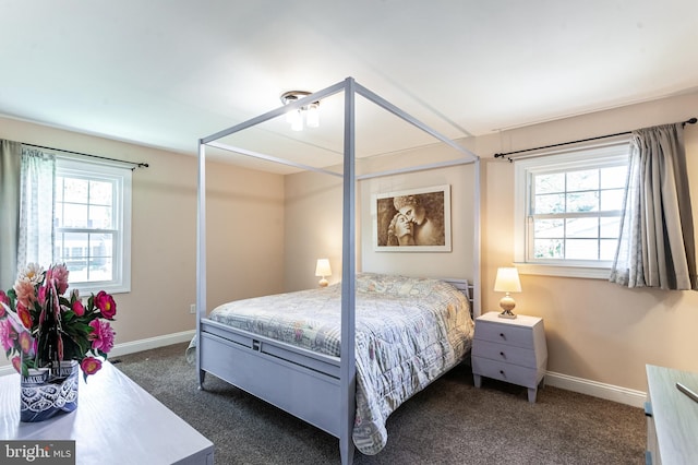 bedroom featuring baseboards and dark carpet