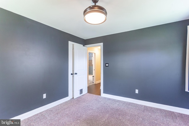 spare room featuring baseboards, carpet flooring, and visible vents