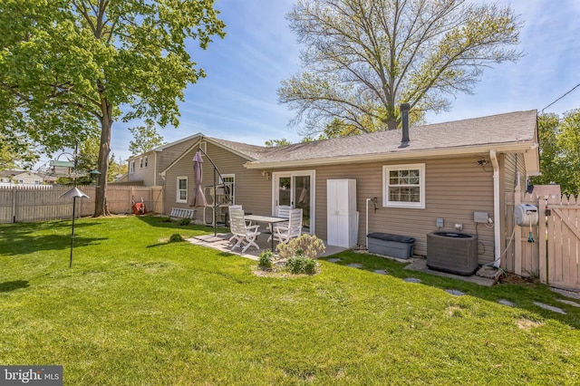rear view of house featuring central air condition unit, a yard, a gate, and a fenced backyard