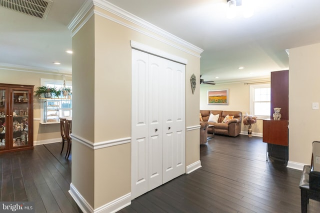 hallway with baseboards, ornamental molding, dark wood-style floors, and visible vents