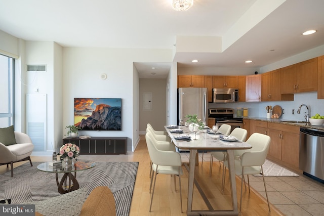 interior space featuring recessed lighting, a sink, brown cabinetry, visible vents, and appliances with stainless steel finishes