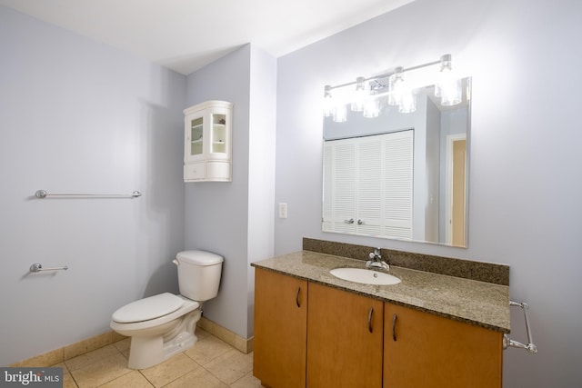 bathroom featuring toilet, tile patterned flooring, vanity, and baseboards