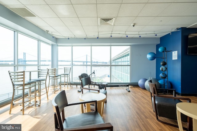 interior space featuring a paneled ceiling, visible vents, and wood finished floors