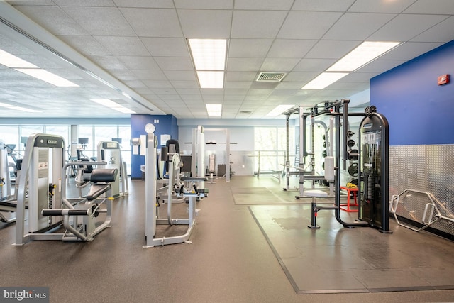 exercise room with visible vents and a paneled ceiling