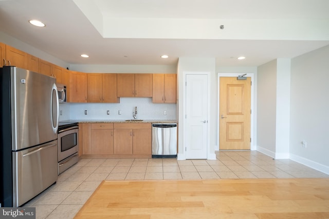 kitchen with recessed lighting, light tile patterned floors, appliances with stainless steel finishes, light countertops, and a sink