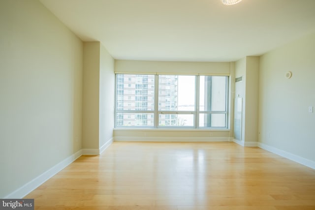 empty room featuring light wood finished floors and baseboards
