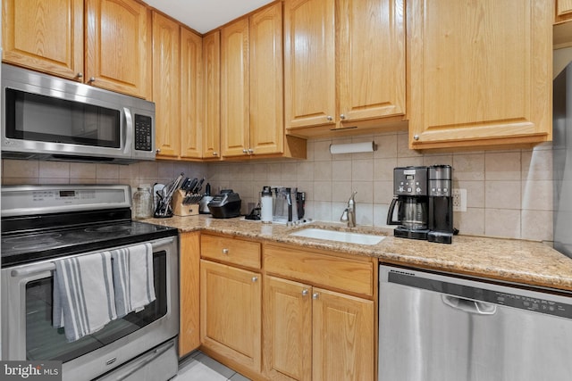 914 Spruce St Unit 9, Philadelphia, PA 19107 - kitchen featuring appliances with stainless steel finishes, light stone counters, decorative backsplash, and a sink