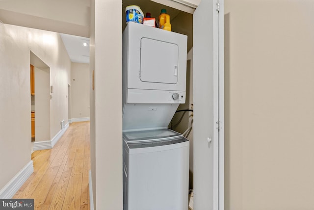 914 Spruce St Unit 9, Philadelphia, PA 19107 - clothes washing area with baseboards, stacked washer and dryer, laundry area, and light wood finished floors