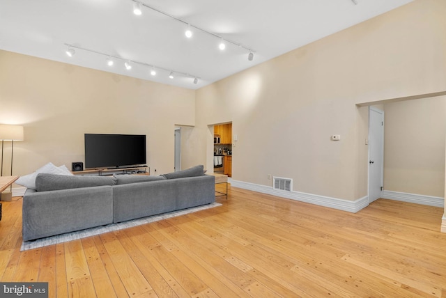 914 Spruce St Unit 9, Philadelphia, PA 19107 - living area with rail lighting, wood-type flooring, baseboards, visible vents, and a towering ceiling