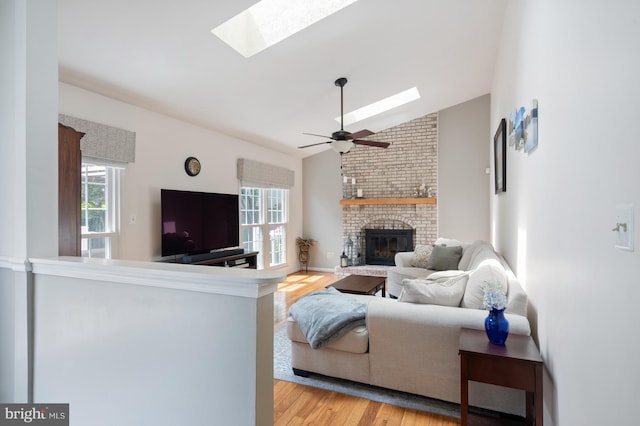 5433 Lomax Way, Woodbridge, VA 22193 - living area with a skylight, light wood finished floors, a fireplace, vaulted ceiling, and a ceiling fan