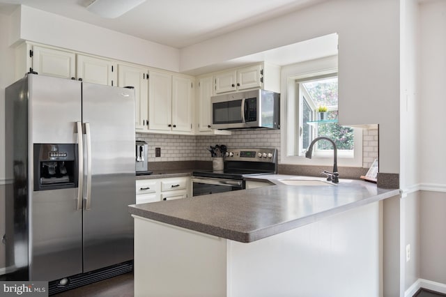 5433 Lomax Way, Woodbridge, VA 22193 - kitchen featuring stainless steel appliances, a sink, a peninsula, dark countertops, and tasteful backsplash