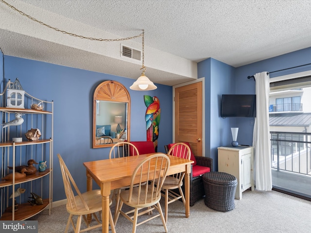 dining space featuring carpet floors, a textured ceiling, and visible vents
