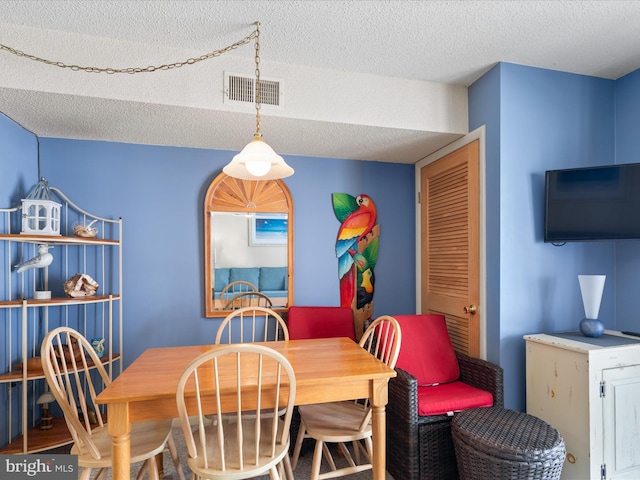dining room featuring visible vents and a textured ceiling