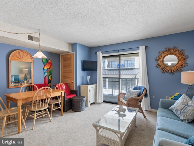 carpeted living area featuring a textured ceiling and visible vents