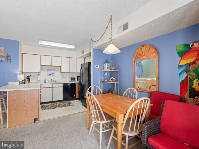 dining area with visible vents, a textured ceiling, and light colored carpet