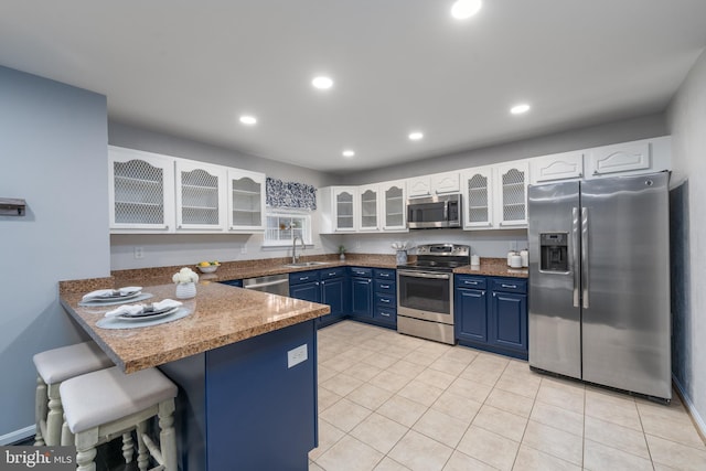 7815 Outing Ave, Pasadena, MD 21122 - kitchen featuring appliances with stainless steel finishes, a sink, blue cabinetry, a peninsula, and a breakfast bar area