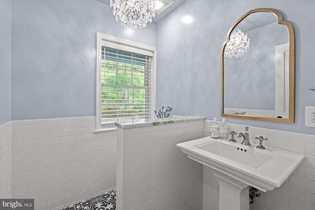 4812 Maury Ln, Alexandria, VA 22304 - bathroom featuring a sink, tile walls, wainscoting, and a notable chandelier