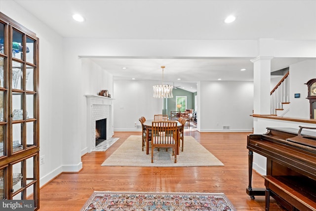 4812 Maury Ln, Alexandria, VA 22304 - dining room featuring a fireplace with flush hearth, light wood-style flooring, stairs, and a wealth of natural light