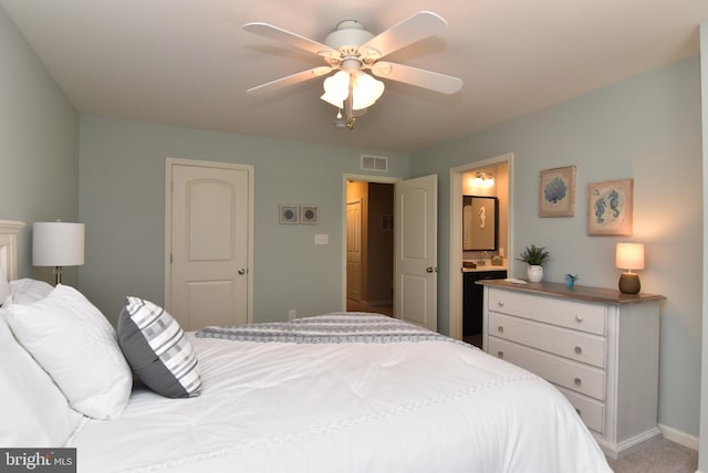 bedroom with carpet, a ceiling fan, baseboards, ensuite bathroom, and visible vents