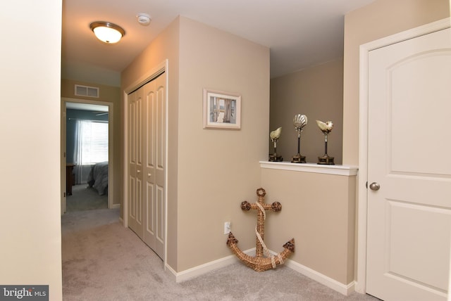 hall featuring baseboards, carpet, and visible vents