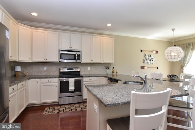 kitchen with crown molding, a sink, a breakfast bar area, stainless steel appliances, and a peninsula