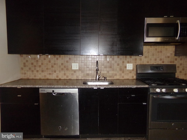 1933 N Palethorp St, Philadelphia, PA 19122 - kitchen with backsplash, dark cabinets, appliances with stainless steel finishes, and a sink