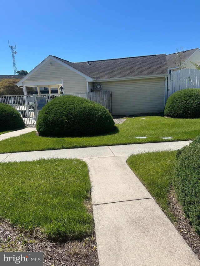 single story home featuring a front lawn and fence