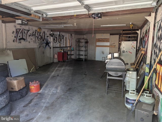 garage with freestanding refrigerator and a garage door opener