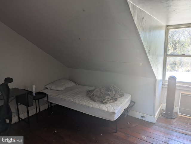 bedroom featuring baseboards, wood-type flooring, and vaulted ceiling