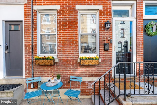 doorway to property with brick siding