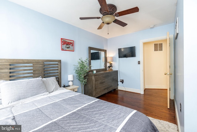 bedroom with a ceiling fan, baseboards, visible vents, and wood finished floors