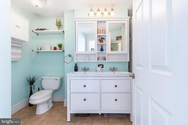 bathroom with double vanity, toilet, tile patterned floors, and a sink