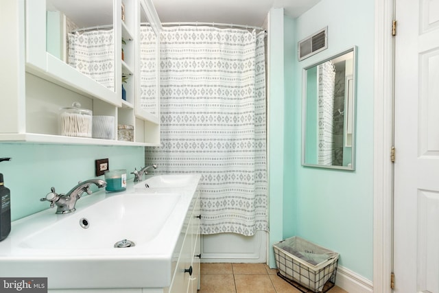 bathroom featuring double vanity, visible vents, a sink, and tile patterned flooring