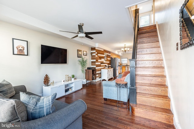 living room featuring stairway, ceiling fan with notable chandelier, and dark wood-style floors