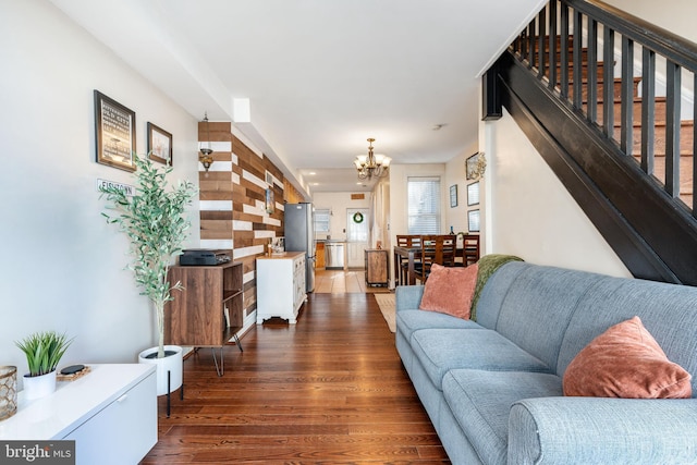living area featuring an inviting chandelier, stairway, and wood finished floors