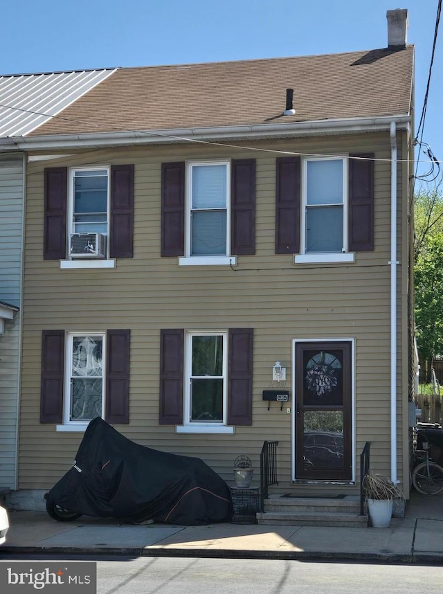 view of front of property featuring roof with shingles, a chimney, cooling unit, and entry steps