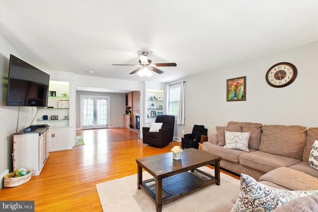 living room with a ceiling fan and light wood finished floors