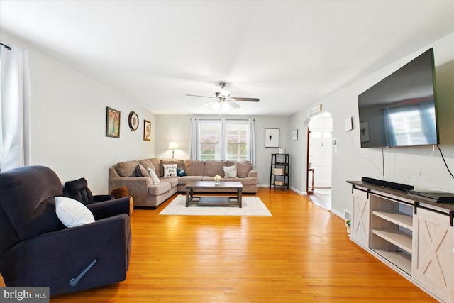 living area with light wood-style floors and a ceiling fan