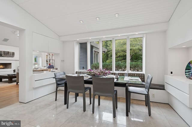 dining room with light tile patterned flooring and vaulted ceiling