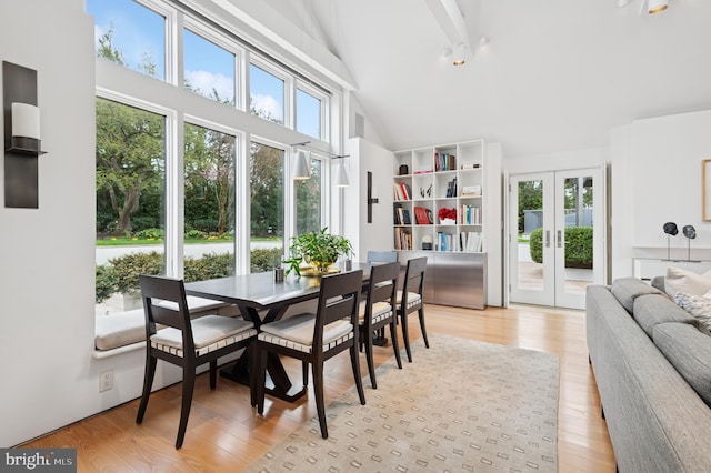 dining area featuring french doors, light wood finished floors, high vaulted ceiling, and beamed ceiling