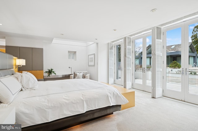 bedroom with french doors, access to outside, and light carpet