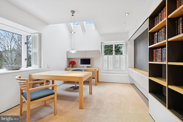 carpeted dining area with a skylight