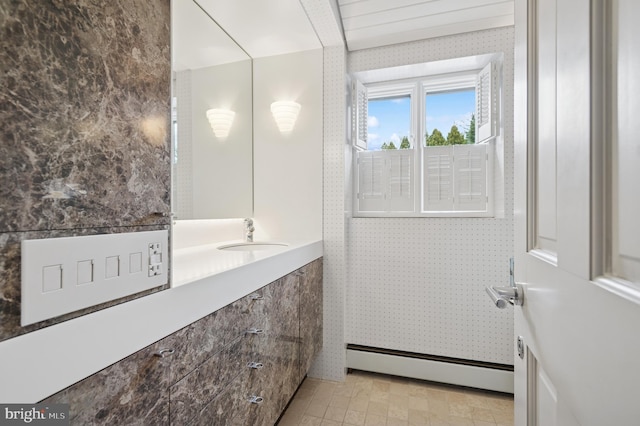 bathroom featuring vanity, wallpapered walls, and a baseboard radiator