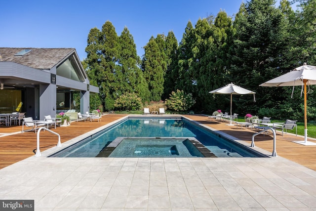 outdoor pool with outdoor dining area, an in ground hot tub, and a wooden deck